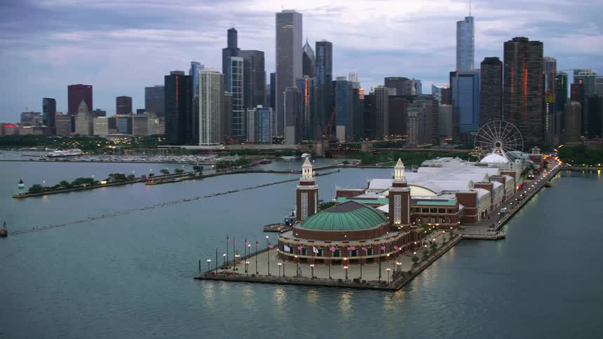 An aerial view of a large ocean pier with skyscrapers in a coastal city