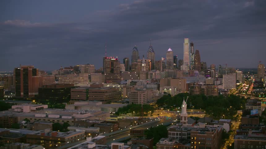 An aerial view of skyscrapers and buildings in a city at night