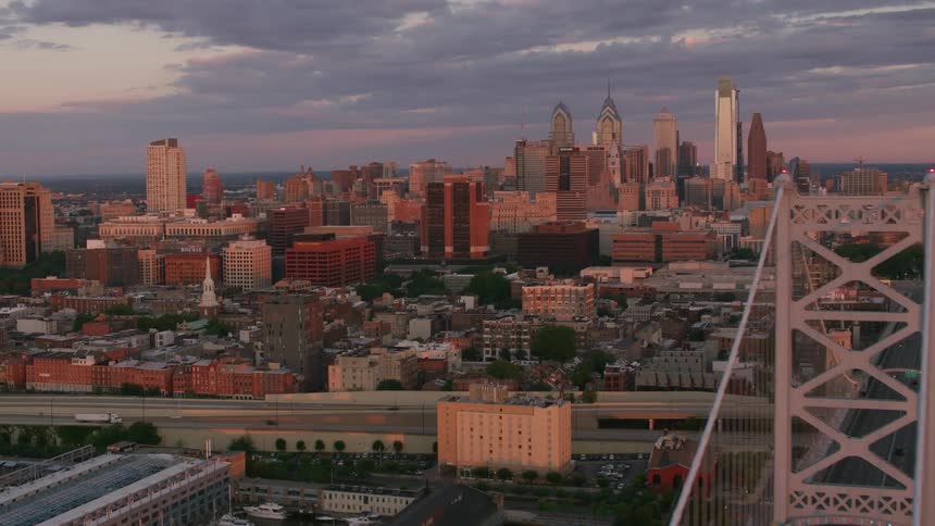 Aerial view of suspension bridge and skyscrapers at dusk