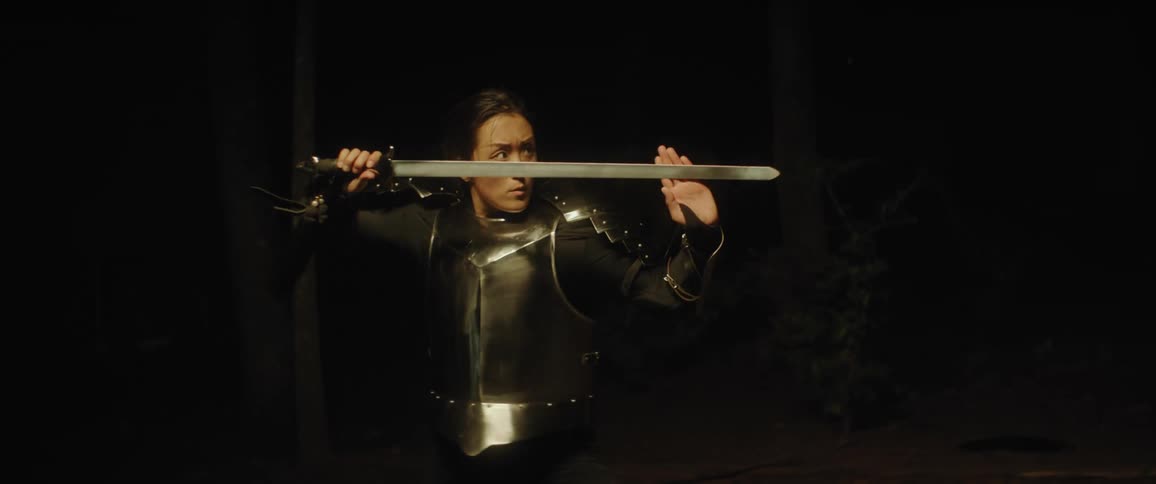 Woman in medieval armour swings sword