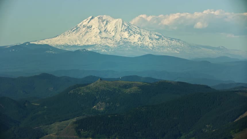 A vast and snowy Mount Adams with foreground hills of the Gifford Pinchot National Forest in the foreground