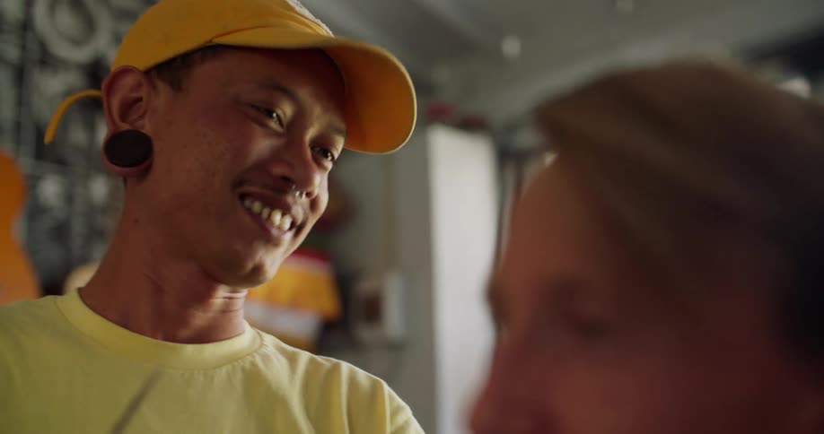 A barber smiling and nodding while cutting a clients hair