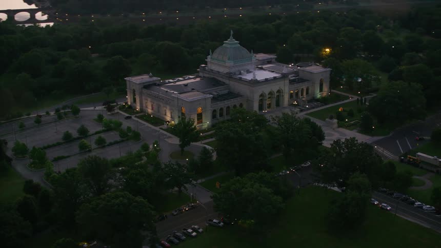 An aerial view of a government building with cars driving past and a river in the background