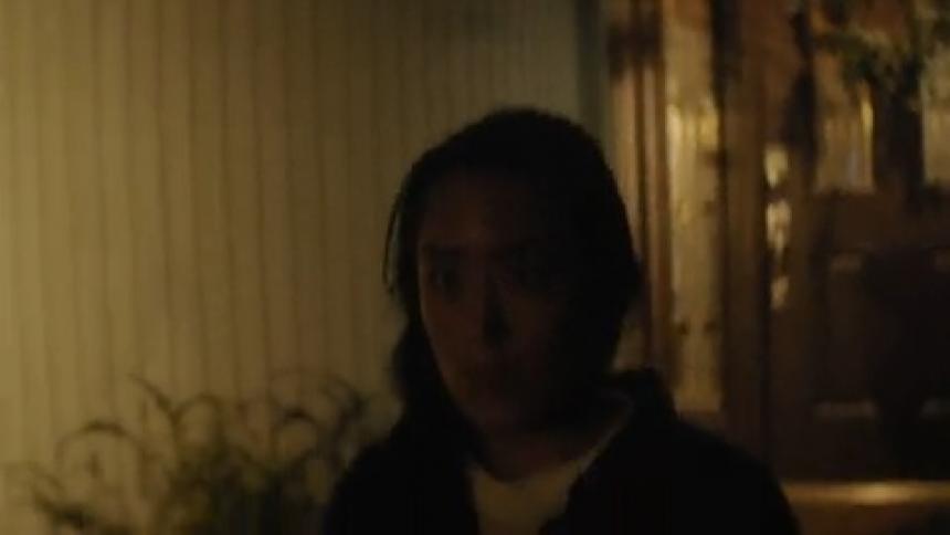 A woman is walking out of her house during the night time