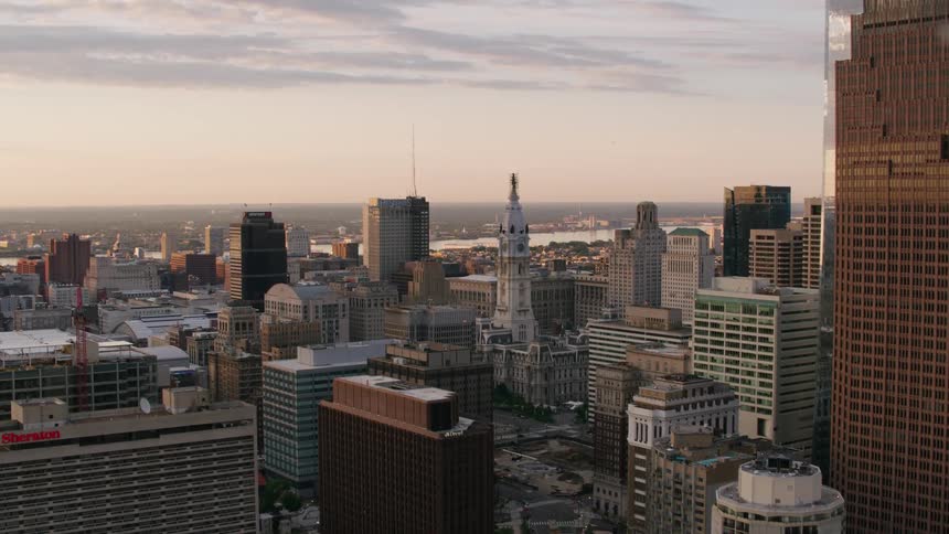 Aerial view of city skyline and office buildings next to river at dusk