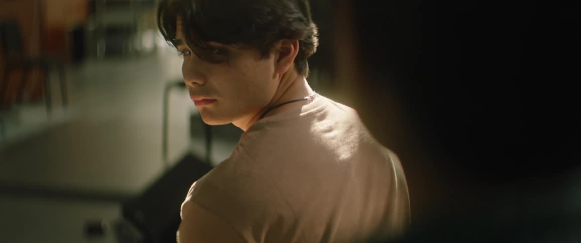 A teenager ignors a friend who taps him on the shoulder to get his attention