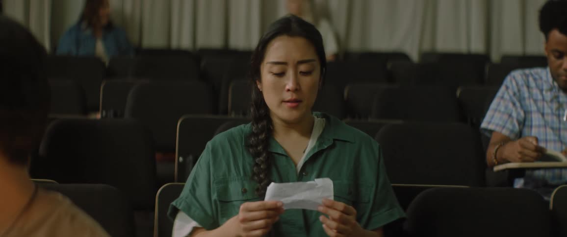 A college student reads and looks at a note in class that upsets her