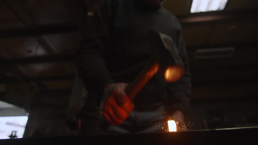 A blacksmith hammering a hot piece of metal