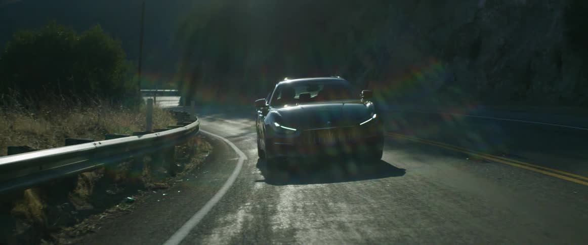A car traveling on a windy road on a sunny day