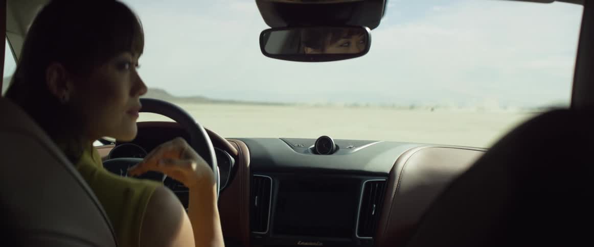A woman is driving a car and keeps looking back