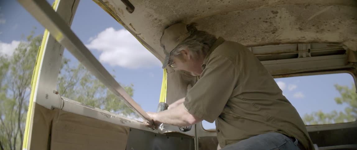 A man is using a drill in a van