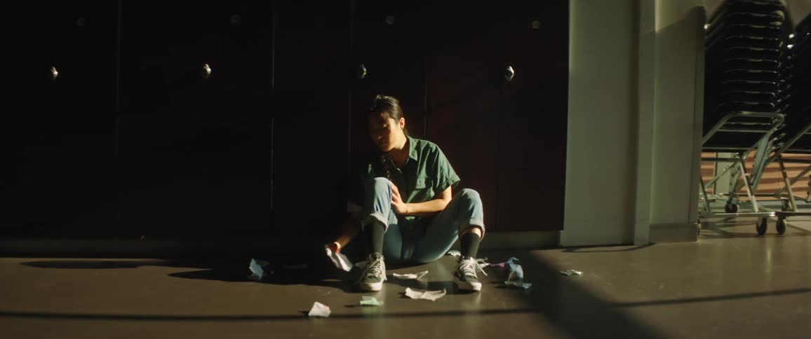 A girl sits by the lockers in the hall