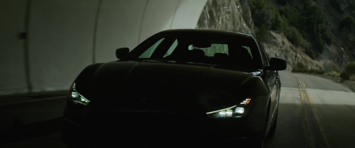 A man is entering a tunnel in a luxury car