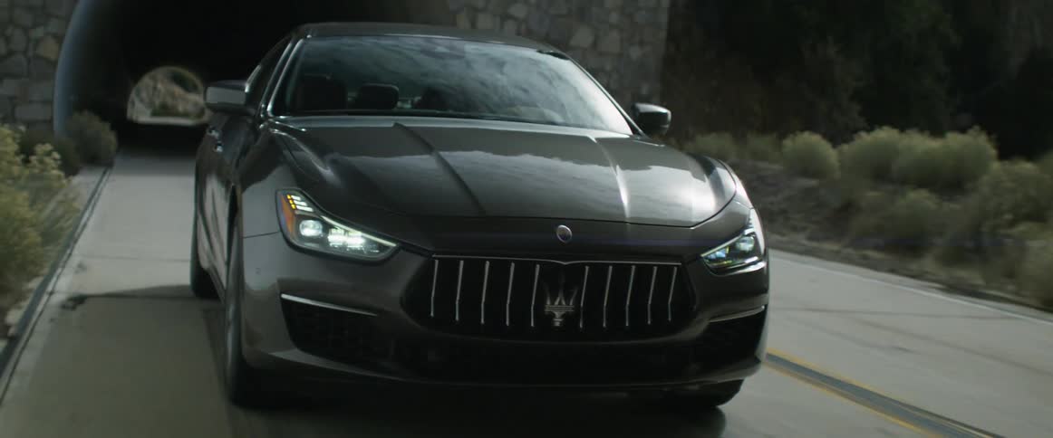 Headlights shine in the darkness as an automobile passes through tunnels on the road
