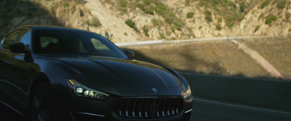 A person is driving a luxury vehicle on a mountain road