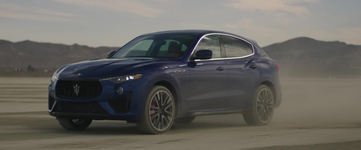 Blue sports car drives across the desert