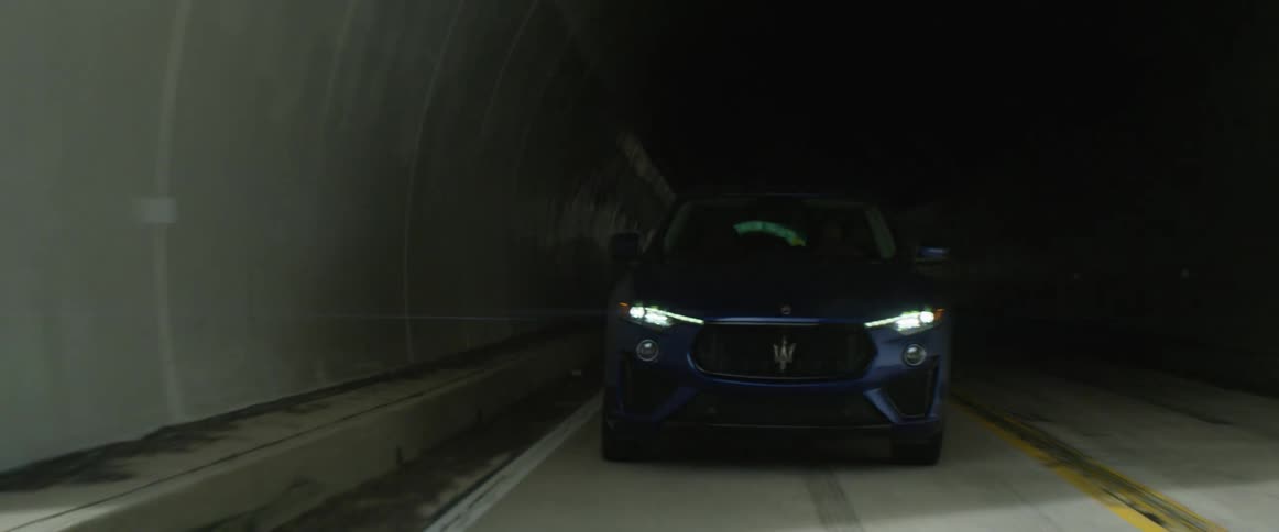 Blue sedan drives out of dark tunnel