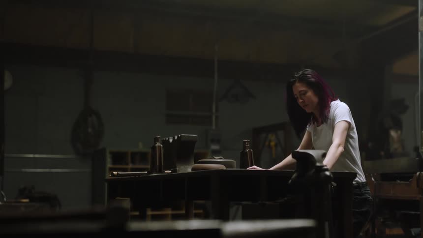 A woman looks upset as she stands and rocks against a table