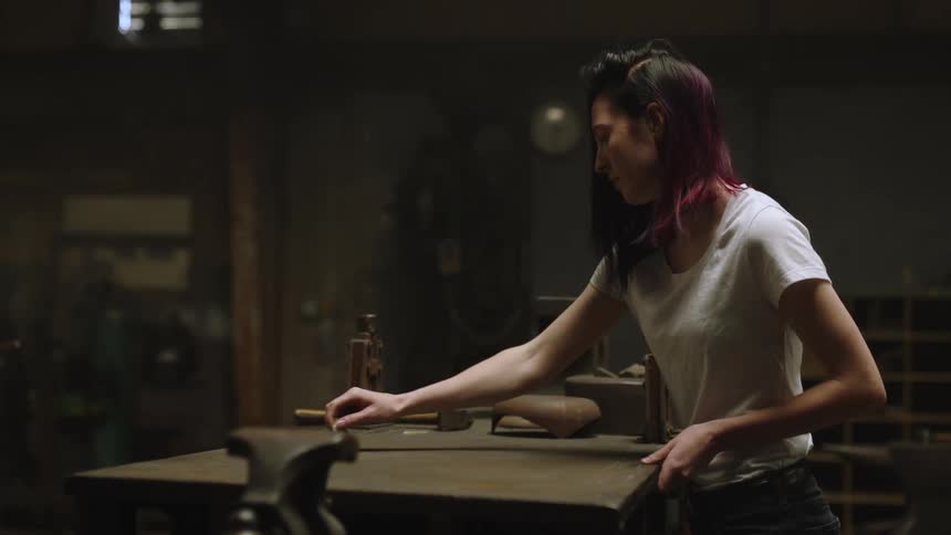 A woman is stratching her nails across a table