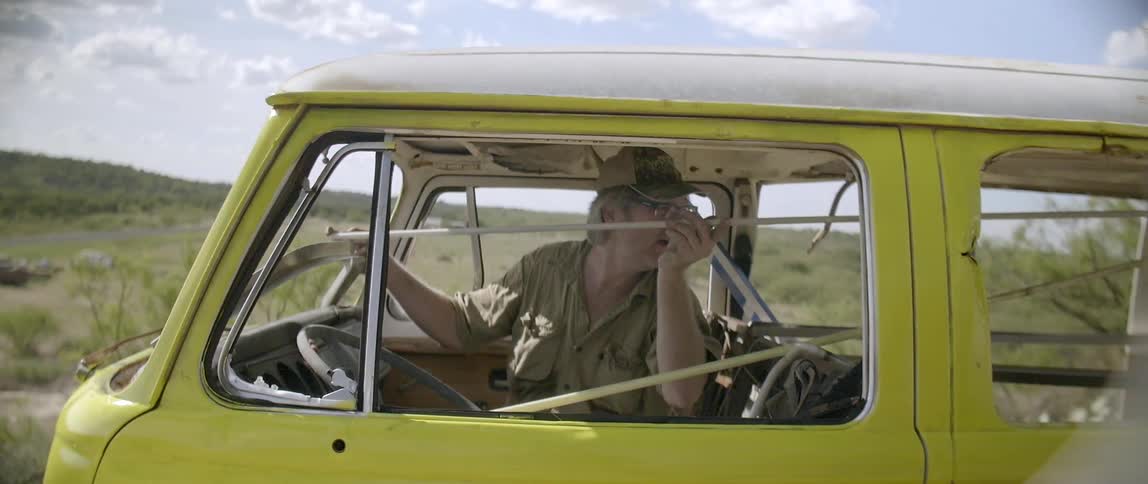 A man moves a rod through a van from the front seat