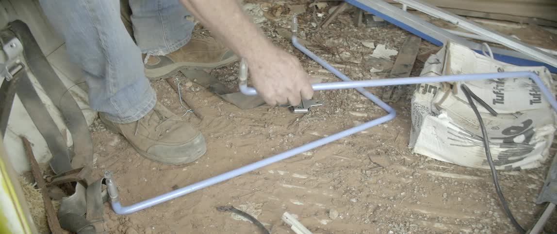 A man picks up a piece of neon tubing from the ground