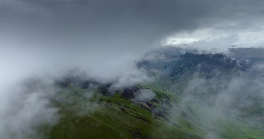 Low lying clouds obscure portions of green mountains