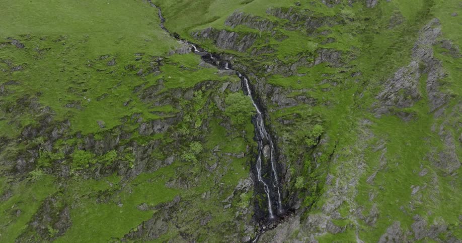 An aerial view of a waterfall flowing in to a river