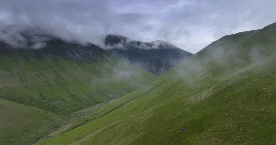 Dense fog settles in the valley between rolling hills