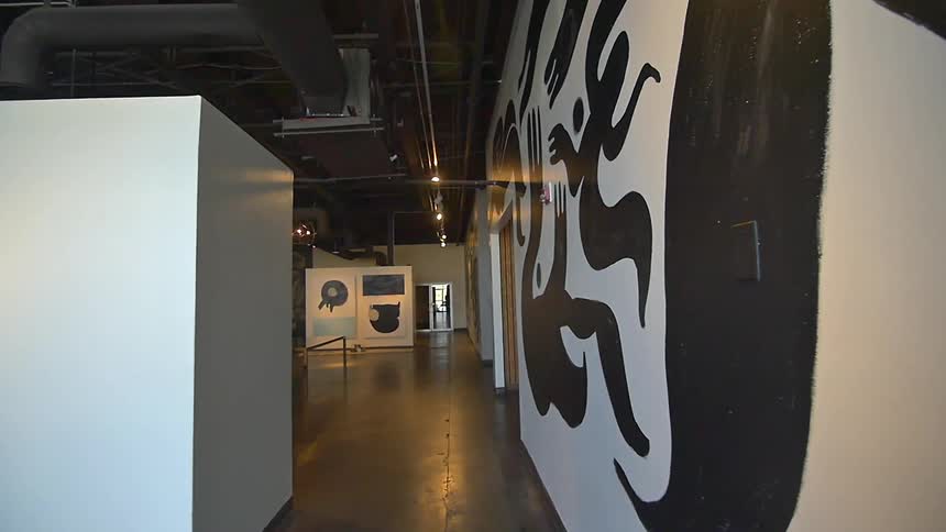 Walking down a hall with art on the wall