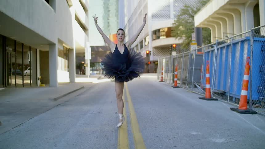 A ballerina dancing along a city street