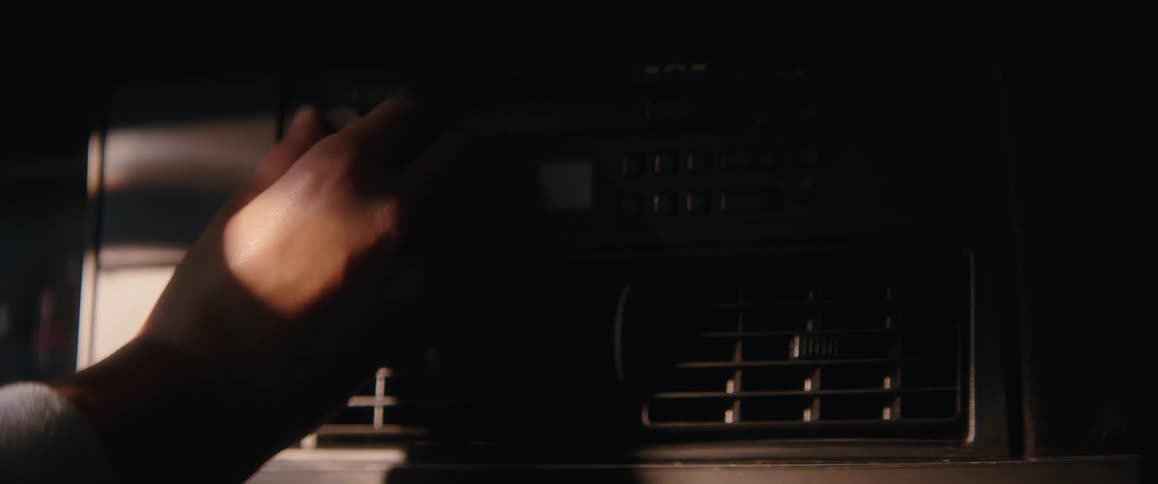 A man adjusts the radio in his vehicle
