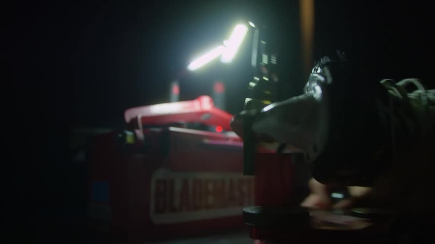 Sparks fly as a man uses a miter saw in a factory