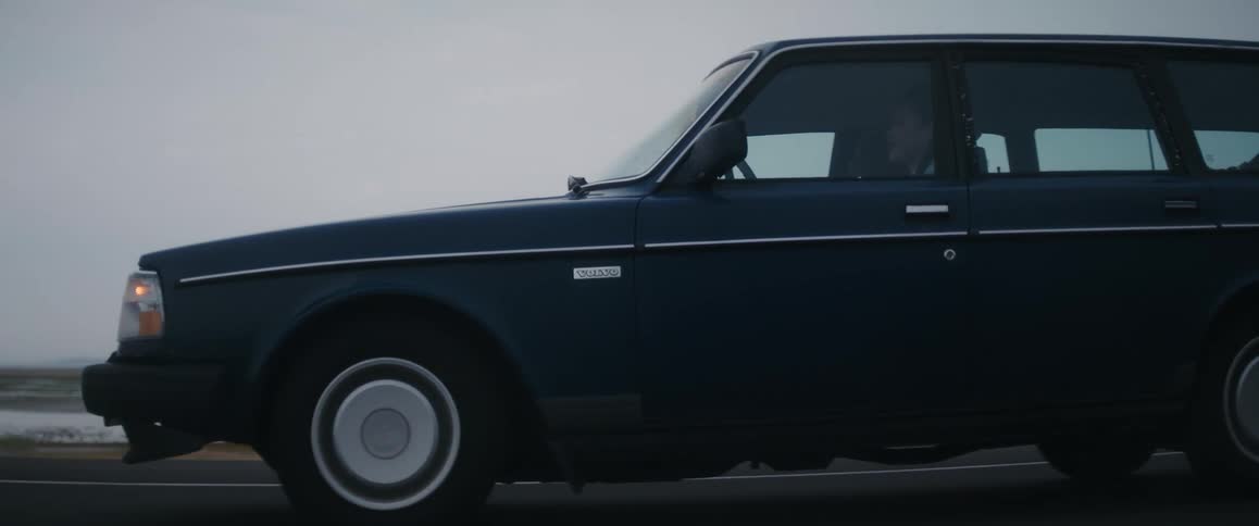 Old volvo wagon driving on a road past the lake in the  morning