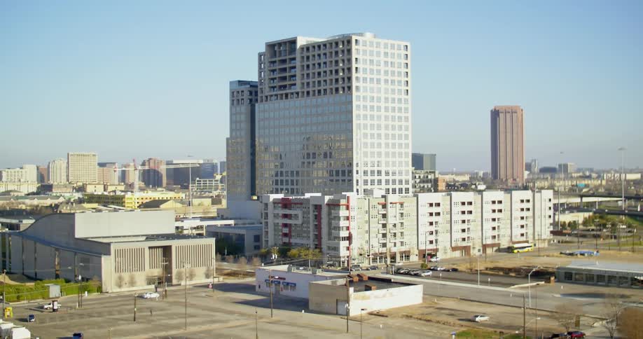 Cars drive on the road near a large building