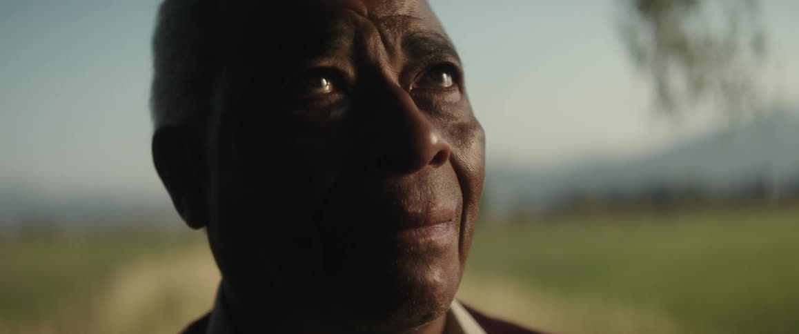 Close up of the face of an elderly blind man standing on a road in the countryside as he remembers the past