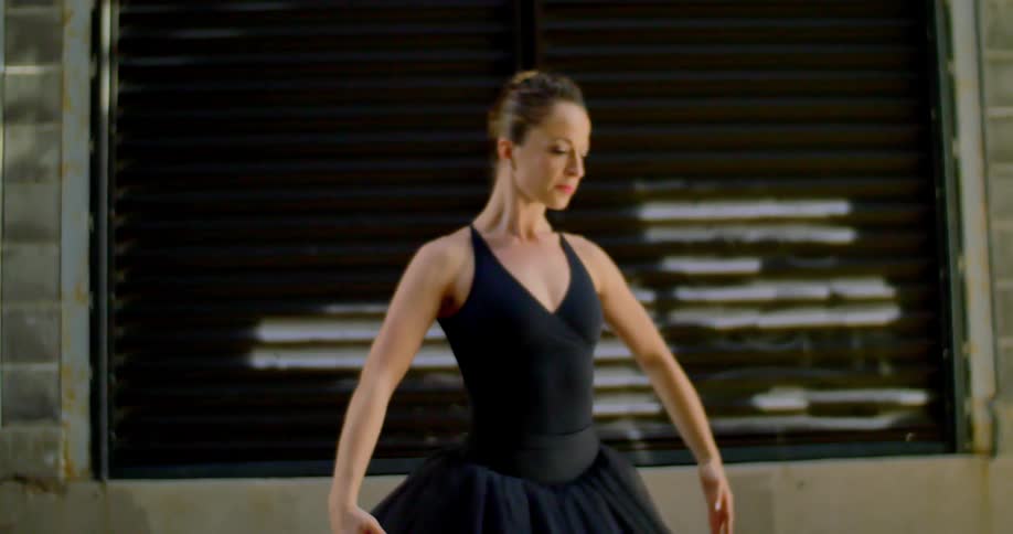 A ballerina practicing in front of a building