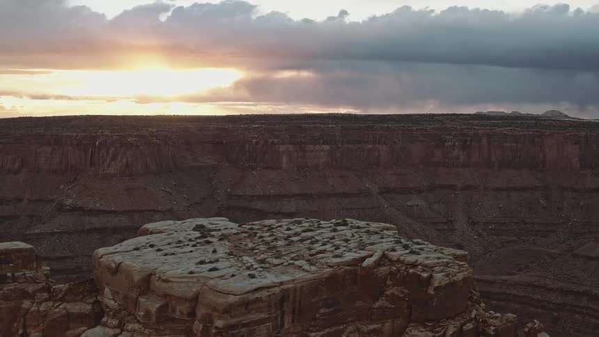 The sun shining through the clouds above a large canyon