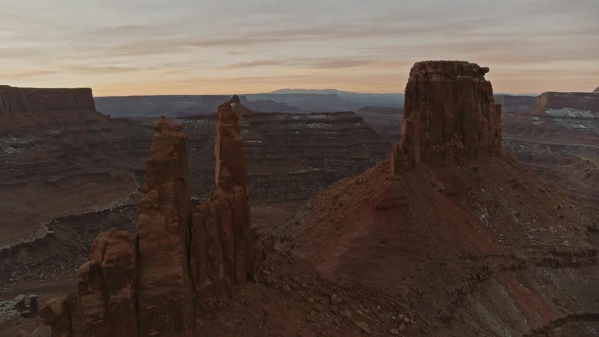 Rock formations atop buttes in a massive canyon in the evening