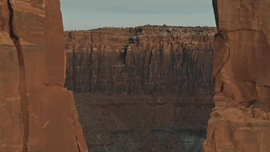 A wide cliff is visible through the space between narrow mesas
