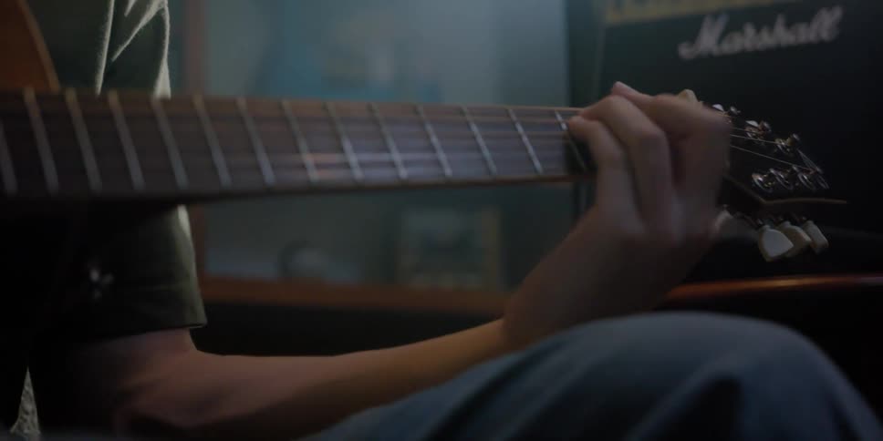 Guitarist playing chords on an acoustic guitar