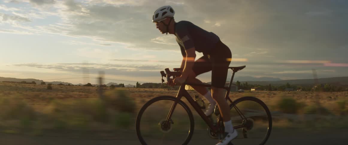A man rides his bicycle past an open field