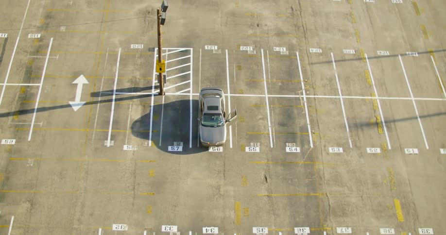 A car drives in a parking lot and parks