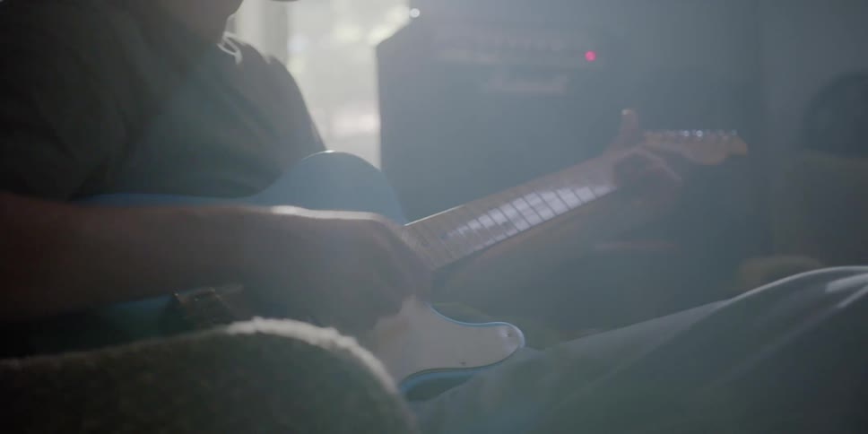 A man plays guitar in a smoke filled room