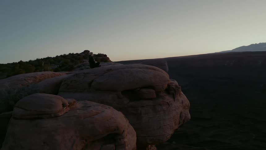 Woman sits cross legged on the top of a mesa