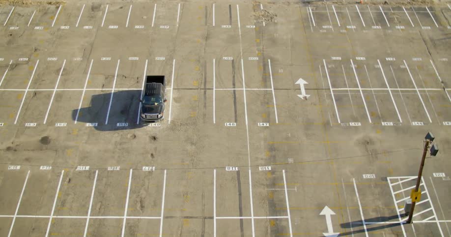 A single truck is parked in an empty parking lot