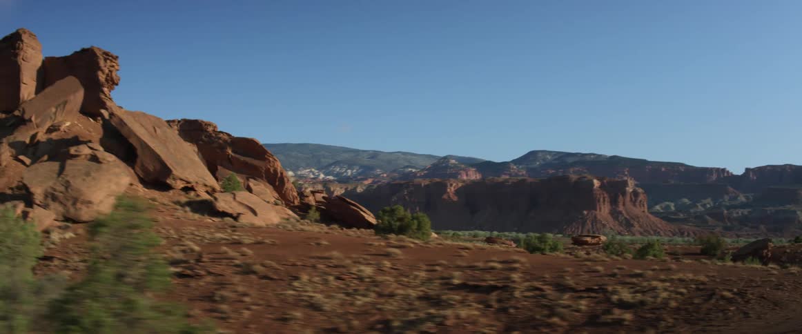 Rocks and boulders on the badlands seen from a moving vehicle at daytime