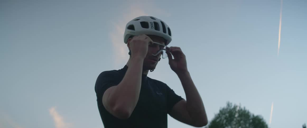A man takes off his cycling helmet and glasses