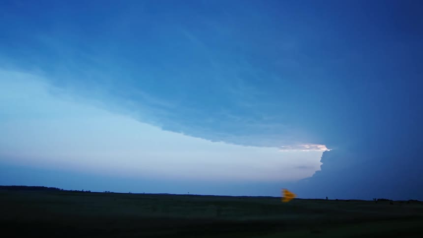 A massive supercell storm and severe thunderstorm anvil are seen as storm chasers urgently drive towards Imperial Nebraska
