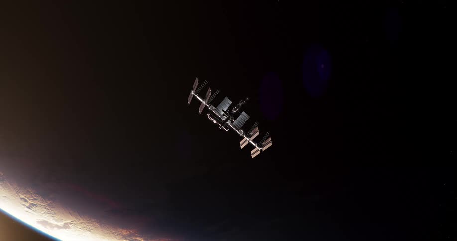 The space station is orbiting at night around a planet