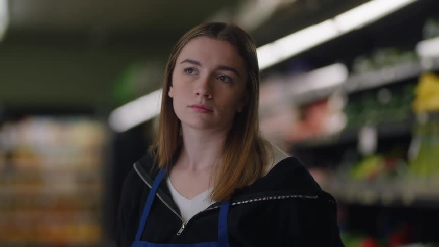 An employee is standing in the grocery store